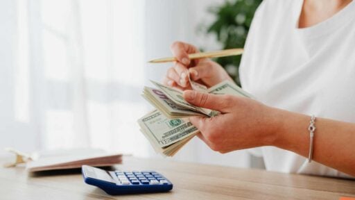 a woman counting bank notes for essential expenses