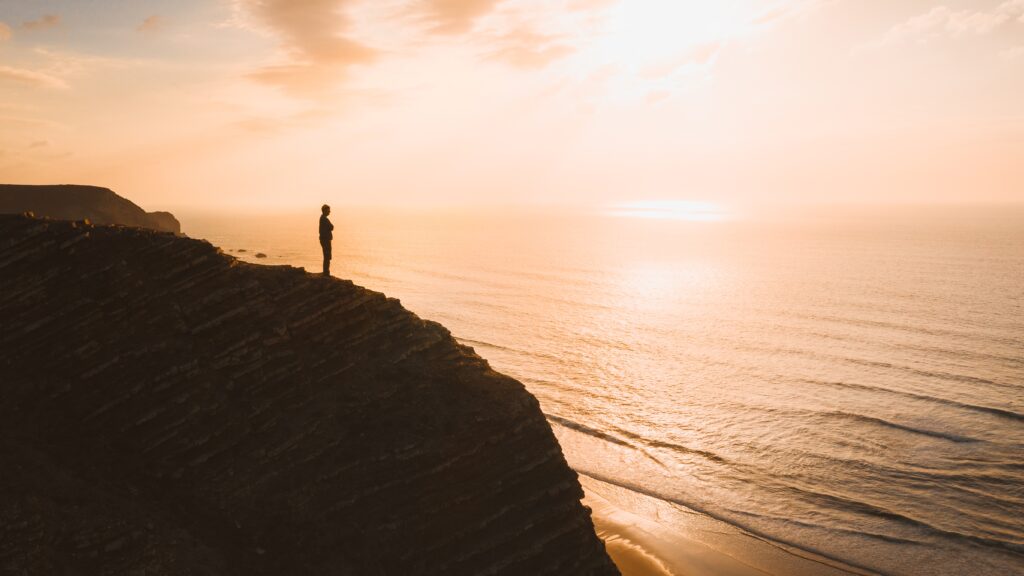 beautiful view person standing cliff ocean sunset algarve portugal