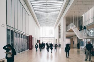 Art enthusiasts are walking along the hallway of art exhibition by the Fine Art Group